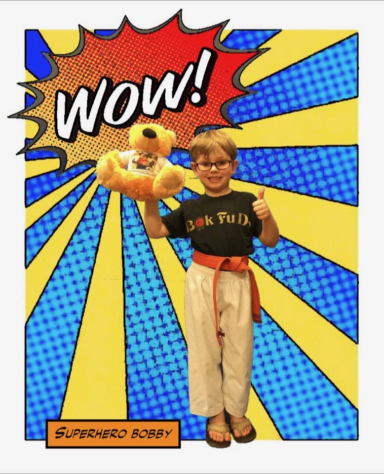 Bobby posing with a teddy bear, superhero-style